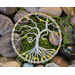 view from above small wire wrap tree of life in bed of river rock and moss